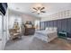 Serene bedroom with decorative accent wall, ceiling fan, dresser, and large windows dressed with curtains to let light in at 6661 Gallup Ct, Pahrump, NV 89060