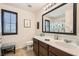 Bright bathroom featuring a dark wood vanity, framed mirror, and a tiled floor at 7154 Brighton Village St, Las Vegas, NV 89166