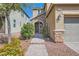 Inviting front entrance with stone accents, landscaping, and a paved walkway leading to the front door at 7154 Brighton Village St, Las Vegas, NV 89166