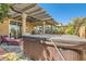 Cozy backyard featuring a relaxing hot tub, comfortable lounge chair, and decorative pergola at 7154 Brighton Village St, Las Vegas, NV 89166