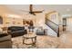 Inviting living room flows into the open kitchen, featuring a ceiling fan and tile flooring at 7154 Brighton Village St, Las Vegas, NV 89166