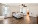 Bright main bedroom with wood-look floors, ceiling fan, and large windows for natural light at 7154 Brighton Village St, Las Vegas, NV 89166