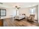 Spacious main bedroom featuring wood-look floors, fan, and comfortable sitting area at 7154 Brighton Village St, Las Vegas, NV 89166