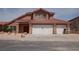 Inviting two-story home featuring a three-car garage and attractive desert landscaping at 7720 Leavorite Dr, Las Vegas, NV 89128