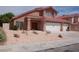 Inviting two-story home featuring a three-car garage and desert landscaping at 7720 Leavorite Dr, Las Vegas, NV 89128