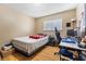 Standard bedroom with window, desk, and a twin bed with a red blanket at 816 Antigua St, Las Vegas, NV 89145