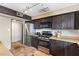 A full kitchen with stainless steel appliances, dark cabinetry, and textured tile floors at 816 Antigua St, Las Vegas, NV 89145
