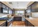 Traditional kitchen featuring a stainless steel oven, dark wood cabinetry, and a window over the sink at 816 Antigua St, Las Vegas, NV 89145