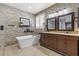 Elegant bathroom featuring a freestanding tub, stone accent wall, and a stylish double vanity at 8220 Tursi Lodge Ct, Las Vegas, NV 89131