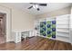 Bedroom features built-in shelves, wood floors, bright windows, and a ceiling fan with light at 8220 Tursi Lodge Ct, Las Vegas, NV 89131