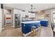 Spacious kitchen featuring a large island, stainless steel refrigerator, white cabinets, and stylish light fixtures at 8220 Tursi Lodge Ct, Las Vegas, NV 89131