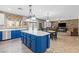 Open-concept kitchen with an island, white countertops, blue cabinetry, and seamless flow to the living area at 8220 Tursi Lodge Ct, Las Vegas, NV 89131