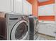 Well-equipped laundry room with modern washer and dryer, ample cabinets, and a convenient sink at 8220 Tursi Lodge Ct, Las Vegas, NV 89131