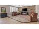 Comfortable living room featuring a stacked stone accent wall, ceiling fan, and plantation shutters at 8220 Tursi Lodge Ct, Las Vegas, NV 89131