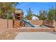 Backyard playground area with a slide, climbing wall, and playhouse at 8220 Tursi Lodge Ct, Las Vegas, NV 89131