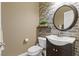 Charming powder room featuring a stylish vanity, round mirror, and unique brick accent wall at 8220 Tursi Lodge Ct, Las Vegas, NV 89131