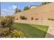 Low maintenance backyard featuring turf, a retaining wall, and block wall fencing at 8393 Canyon Crevasse St, Las Vegas, NV 89166
