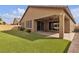 Landscaped backyard featuring a covered patio, artificial turf, and lush greenery, ideal for relaxation at 8393 Canyon Crevasse St, Las Vegas, NV 89166