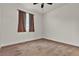 Empty bedroom with brown carpet, large window and a ceiling fan at 8393 Canyon Crevasse St, Las Vegas, NV 89166