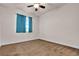 This bedroom features neutral walls, carpeted floors, ceiling fan, and a window with blue curtains at 8393 Canyon Crevasse St, Las Vegas, NV 89166