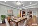 Elegant dining room with stylish light fixture, seating for six, and view of the modern kitchen at 8393 Canyon Crevasse St, Las Vegas, NV 89166
