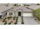 An elevated view of a well-maintained, single-story home with a tile roof, desert landscaping, and a two-car garage at 8393 Canyon Crevasse St, Las Vegas, NV 89166