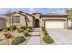 Beautifully landscaped front exterior features desert landscaping, a tile roof, and a paver driveway at 8393 Canyon Crevasse St, Las Vegas, NV 89166