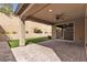 The covered patio with a ceiling fan, stone columns, and an adjacent artificial turf, is perfect for outdoor relaxation at 8393 Canyon Crevasse St, Las Vegas, NV 89166