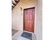 Condo front door featuring a secure brown door, exterior light fixture, and door number at 8501 W University Ave # 1128, Las Vegas, NV 89147