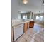 Bright kitchen with white appliances, breakfast bar, tile countertops, and wood cabinets at 8501 W University Ave # 1128, Las Vegas, NV 89147