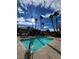 Community pool with manicured landscaping, palm trees, and lounge chairs at 8501 W University Ave # 1128, Las Vegas, NV 89147
