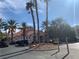 Community entrance features palm trees, desert landscaping, and Spanish-style architecture with red tile roof at 8555 W Russell Rd # 1078, Las Vegas, NV 89113