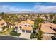 Aerial view of a home featuring desert landscaping, a three-car garage, and a well-maintained tile roof at 8816 Saint Pierre Dr, Las Vegas, NV 89134