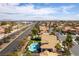 Expansive aerial view of a desert property featuring a beautiful pool and lush landscaping, with city views on the horizon at 8816 Saint Pierre Dr, Las Vegas, NV 89134