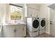 Bright laundry room featuring white cabinets, sink, counter, and modern washer and dryer at 8816 Saint Pierre Dr, Las Vegas, NV 89134