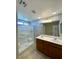 Bright bathroom featuring double sink vanity and walk-in shower with glass enclosure at 9136 Cocowoods Pl, Las Vegas, NV 89148