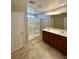 Bright bathroom featuring double sink vanity and walk-in shower with glass enclosure at 9136 Cocowoods Pl, Las Vegas, NV 89148
