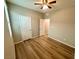 Bright bedroom featuring wood floors, ample closet space, and a ceiling fan at 9136 Cocowoods Pl, Las Vegas, NV 89148
