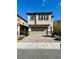 Two-story home with neutral stucco, brown accents, and a brick driveway at 9136 Cocowoods Pl, Las Vegas, NV 89148