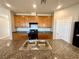 Spacious kitchen with granite countertops, and large island with double sinks and black appliances at 9136 Cocowoods Pl, Las Vegas, NV 89148