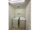 Laundry room with white washer, dryer, and wire shelving at 9136 Cocowoods Pl, Las Vegas, NV 89148