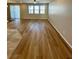 Open-concept living area with wood flooring and multiple large windows for natural light at 9136 Cocowoods Pl, Las Vegas, NV 89148