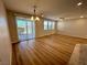 Bright living room with wood floors, natural light from large sliding doors, and modern ceiling fan at 9136 Cocowoods Pl, Las Vegas, NV 89148