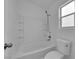 Neutral bathroom featuring tiled bathtub, white walls, and modern fixtures at 9315 Indian Corn Ct # 101, Las Vegas, NV 89178