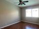 Relaxing bedroom with hardwood floors, a ceiling fan, and a window bringing in natural light at 9436 Silvaner Ct, Las Vegas, NV 89123