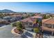 Expansive aerial view of a suburban neighborhood featuring well-maintained homes, manicured lawns, and scenic mountain views at 948 Mill Run Creek Ave, Henderson, NV 89002