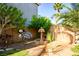 Tranquil backyard featuring a decorative fountain, mature trees, and privacy fencing at 948 Mill Run Creek Ave, Henderson, NV 89002