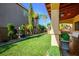 Serene backyard with lush green grass, well-maintained landscaping, and covered patio at 948 Mill Run Creek Ave, Henderson, NV 89002