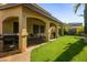 Covered patio in a backyard with green grass and a barbecue at 948 Mill Run Creek Ave, Henderson, NV 89002