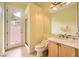 Bright bathroom featuring a door to the courtyard, a vanity with a white countertop, and a matching toilet at 9733 Camden Hills Ave, Las Vegas, NV 89145